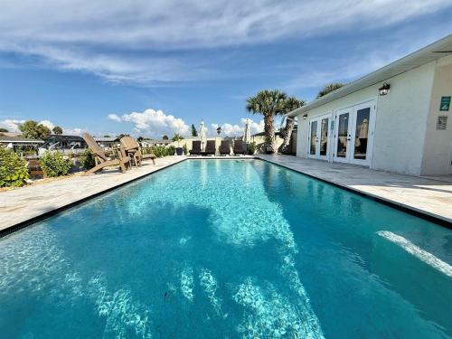 a swimming pool with blue water in front of a house at Brand New Pool! Waterfront Canal Luxury Home in Apollo Beach