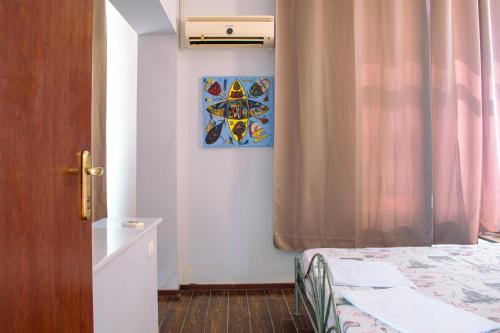 a bedroom with a bed and a painting on the wall at ElStefanino House in Eforie Nord