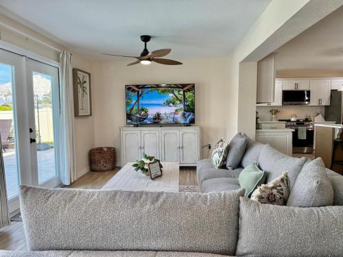 a living room with a couch and a ceiling fan at Brand New Pool! Waterfront Canal Luxury Home in Apollo Beach