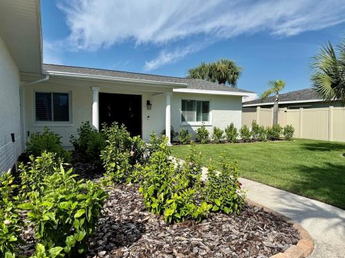 a house with a yard with plants in front of it at Brand New Pool! Waterfront Canal Luxury Home in Apollo Beach