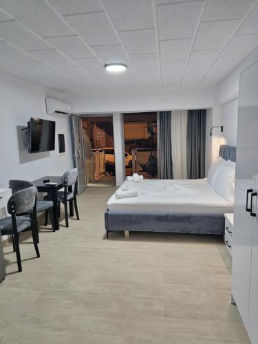 Una habitación de hotel con una cama, una mesa y sillas. en Saranda Apartments Izabela, en Sarandë