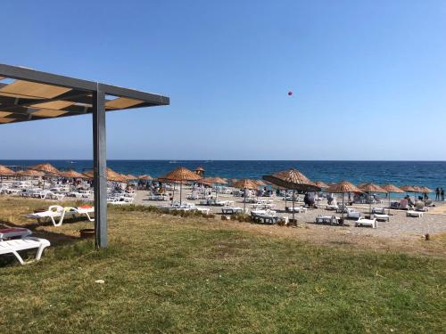 ein Strand mit Stühlen und Sonnenschirmen und das Meer in der Unterkunft Ayshira Aparts in Kemer