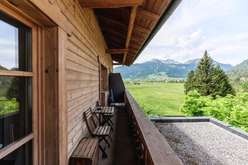 a porch with benches and a view of mountains at Mellow Mountain Hostel in Ehrwald