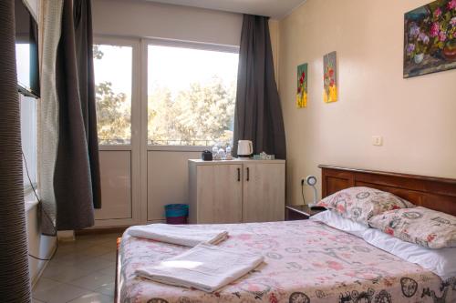 a bedroom with a bed and a large window at ElStefanino House in Eforie Nord