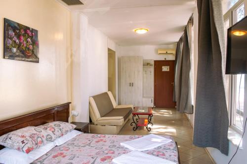 a hotel room with a bed and a chair at ElStefanino House in Eforie Nord