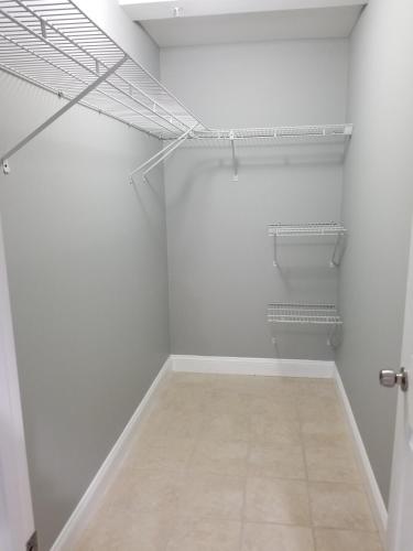 an empty closet with white walls and a tile floor at Gigi's luxurious Arora Hills 2 BdRm, 2 Baths Apt in Clarksburg