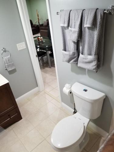 a bathroom with a toilet and towels hanging on a wall at Gigi's luxurious Arora Hills 2 BdRm, 2 Baths Apt in Clarksburg