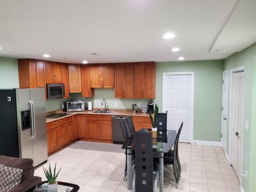 a kitchen with wooden cabinets and a table with chairs at Gigi's luxurious Arora Hills 2 BdRm, 2 Baths Apt in Clarksburg