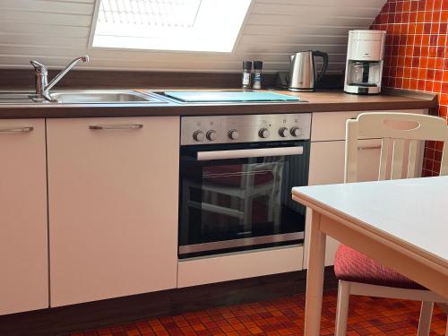 a kitchen with a stove and a sink at Ferienwohnung Klahn Neue Tiefe in Neue Tiefe Fehmarn
