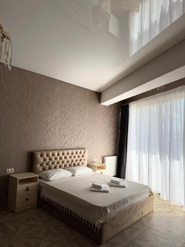 a bedroom with a large bed and a window at Shato Mash in Tbilisi City