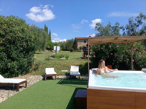 a woman in a hot tub in a garden at Casetta dell`Uliveto in Macchiascandona