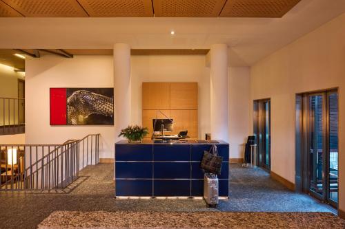 an office lobby with a blue desk and a painting on the wall at The Omnia in Zermatt