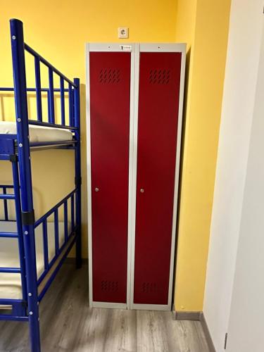 a pair of red doors in a room with bunk beds at Hostel Pinneberg in Pinneberg