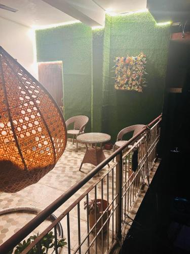 a balcony with a table and chairs and an umbrella at The Hp 39 House in Dharmsala