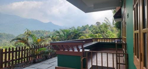 a balcony of a house with a view of the mountains at Wayanad views in Vythiri