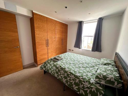 a small bedroom with a bed and a window at Seaside Apartment, on the doorstep of the Beach! in Margate