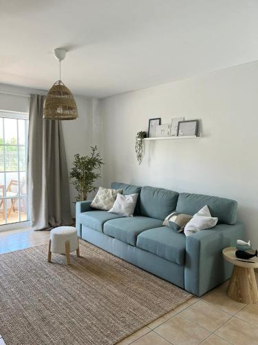 a blue couch sitting in a living room at Cabanas De Miramar in Tavira