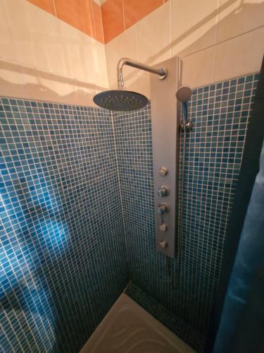 a bathroom with a shower with blue tiles at 2 CHAMBRES chez nous Sorties A62 6 ou 6 1 in Saint-Laurent