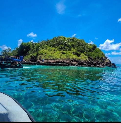 a small island in the water next to a boat at Sea Breeze inn in Providencia