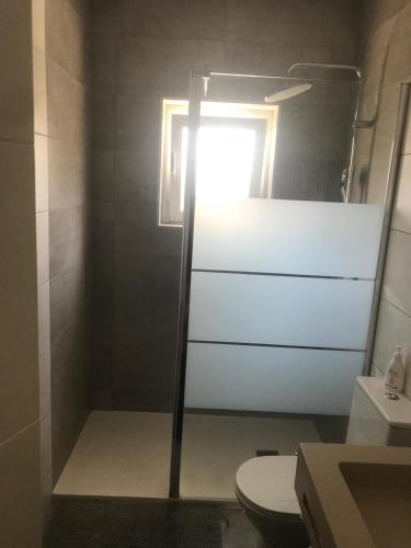 a bathroom with a toilet and a sink and a mirror at Casa da Caroxinha in Quinta do Conde