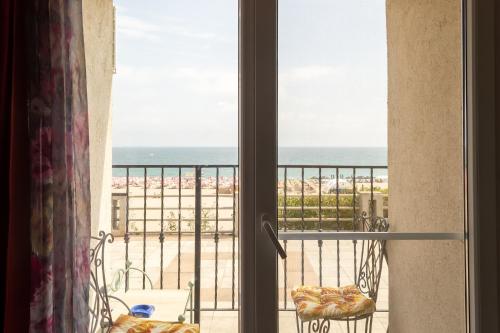 a room with a view of the ocean from a balcony at ElStefanino House in Eforie Nord