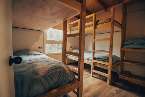 a bedroom with two bunk beds and a window at Aldea Molco Cabaña PEWEN in Villarrica