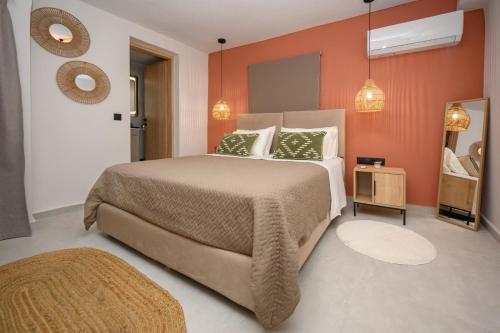 a bedroom with a large bed with orange walls at La casa di Antonio Corfu in Alepou