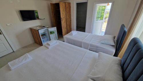 a hotel room with two beds and a television at Mery Inn in Pamukkale