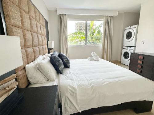 リオ・アトにあるBeach Apartment At Nikki Residences 2 Bedroomの大きな白いベッドと窓のある寝室