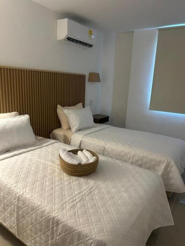 a hotel room with two beds and a basket on the bed at Vicmag House Barranquilla in Barranquilla