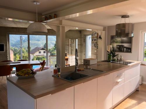 a kitchen with a counter with a sink and a table at Vivez l'Alsace! Piscine, Montagne&Noël Magique in Thann