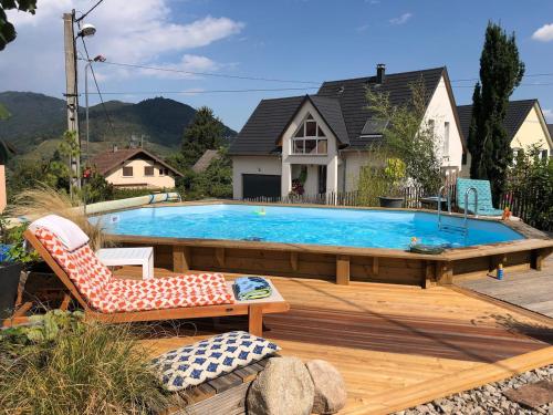 a large swimming pool on a wooden deck with a chair and a couch at Vivez l'Alsace! Piscine, Montagne&Noël Magique in Thann