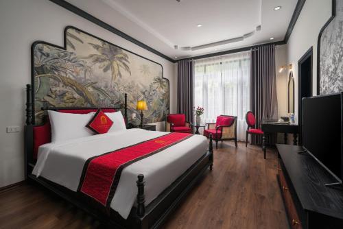 a hotel room with a bed and a television at Indochine Boutique Hotel Ninh Bình in Ninh Binh