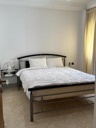 a bed with white sheets and pillows in a bedroom at دوبليكس ميرامار مرتيل in Martil
