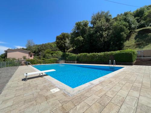 a swimming pool with a bench in a yard at Residenza Le Agavi in Capoliveri in Capoliveri