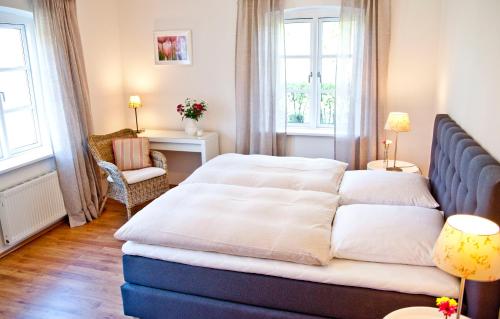 een slaapkamer met een bed, een stoel en ramen bij Ferienwohnung Ella in Scharbeutz
