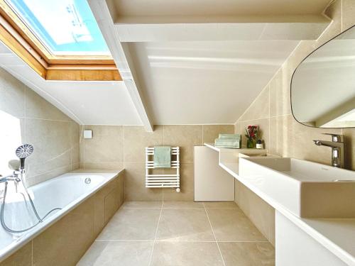 a bathroom with a large tub and a sink at Villa luxueuse avec piscine chauffée in Gujan-Mestras