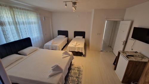 a hotel room with two beds and a television at Mery Inn in Pamukkale