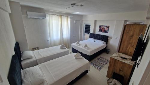 a hotel room with two beds and a television at Mery Inn in Pamukkale