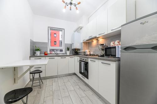 a kitchen with white cabinets and a counter top at JAD - Comfortable -3 Rooms & 2 Rooms Apartments in Braşov