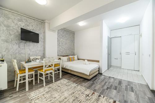a living room with a bed and a table with chairs at JAD - Comfortable -3 Rooms & 2 Rooms Apartments in Braşov
