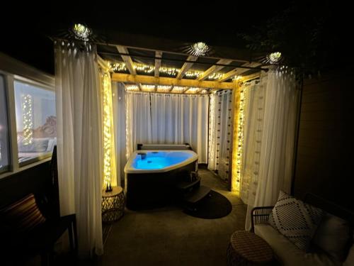 a bathroom with a tub in a room with lights at Crystal Serenity Quartz Soak The Namaste Studio On Lake Hamilton in Hot Springs