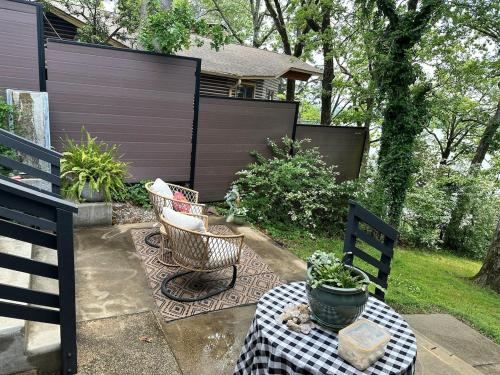 a patio with two chairs and a table and a fence at Crystal Serenity Quartz Soak The Namaste Studio On Lake Hamilton in Hot Springs