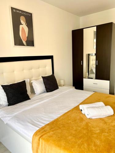 a bedroom with a large white bed with a gold blanket at JAD - Comfortable -3 Rooms & 2 Rooms Apartments in Braşov