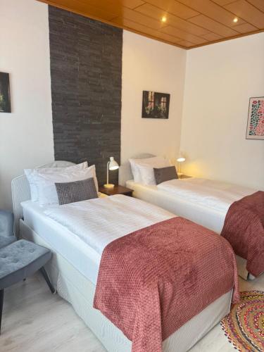 a bedroom with two beds and a brick wall at Mahesars Home 2 in Ennepetal