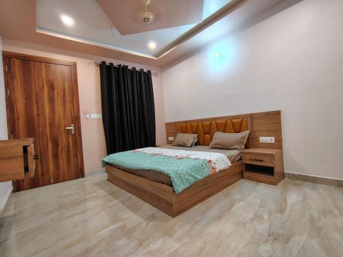a bedroom with a bed and a wooden door at Hotel pinaka in Vrindāvan