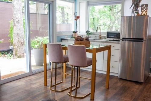 a kitchen with a table and two chairs and a refrigerator at Crystal Serenity Quartz Soak The Namaste Studio On Lake Hamilton in Hot Springs