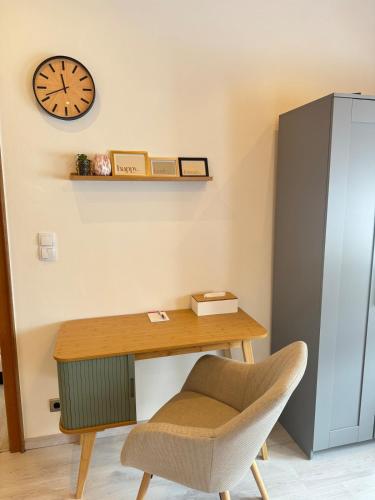 a desk with a chair and a clock on the wall at Mahesars Home 2 in Ennepetal