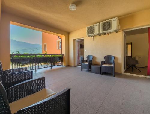 a room with chairs and a balcony with a view at House Šapina in Korenica