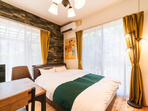 a bedroom with a bed and a desk and window at 88kawaramachi 一軒家 in Takamatsu